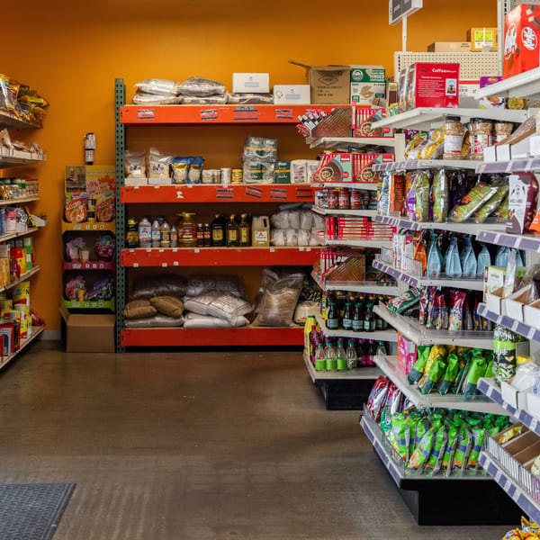 A grocery store aisle with shelves stocked with various packaged foods, spices, and beverages.